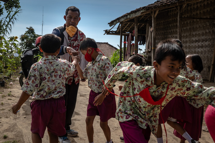 Students greet their home school teacher in Indonesia