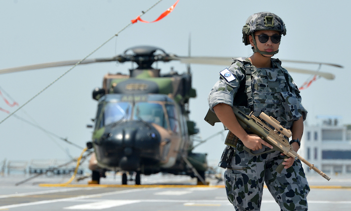 An Australian navy patrolman watches a ship