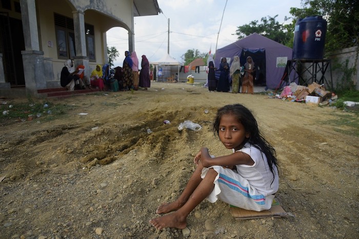 Rohingya refugee girl sits on a track