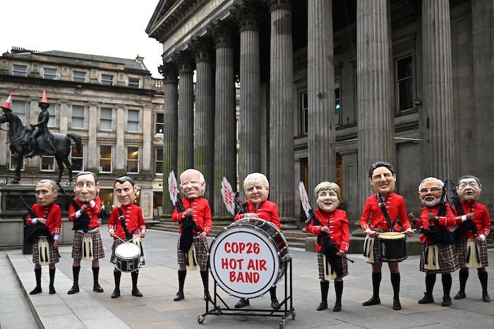 Oxfam activists dressed as a Scottish pipe band protest at COP26