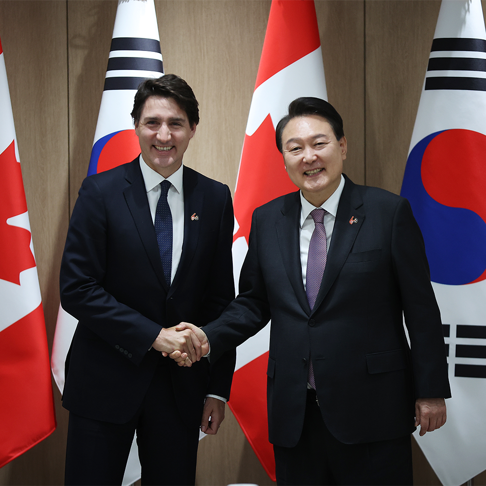 Canada's Prime Minister Justin Trudeau (L) shakes hands with South Korea's President Yoon Suk Yeol