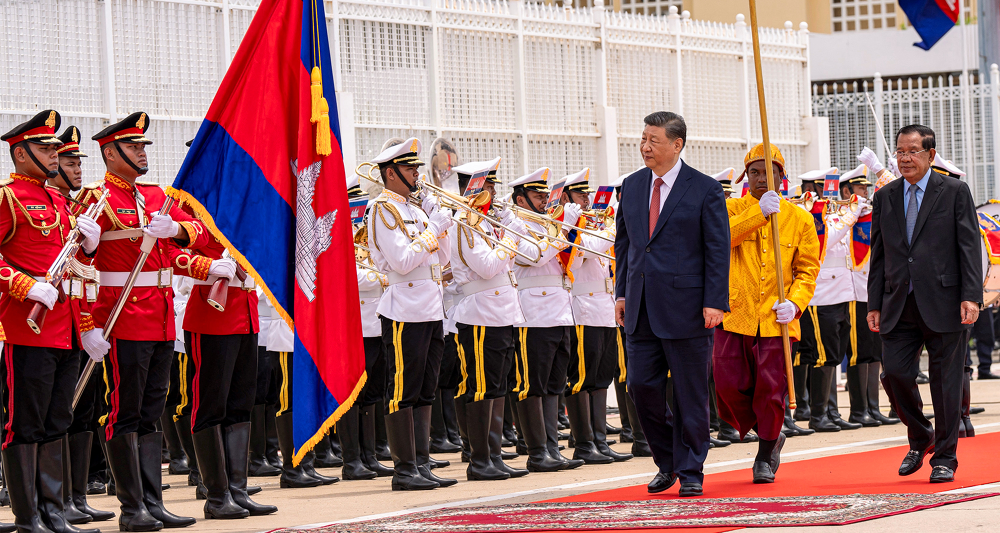 China's President Xi Jinping (C-R) walks with Cambodia's Senate President Hun Sen (R)