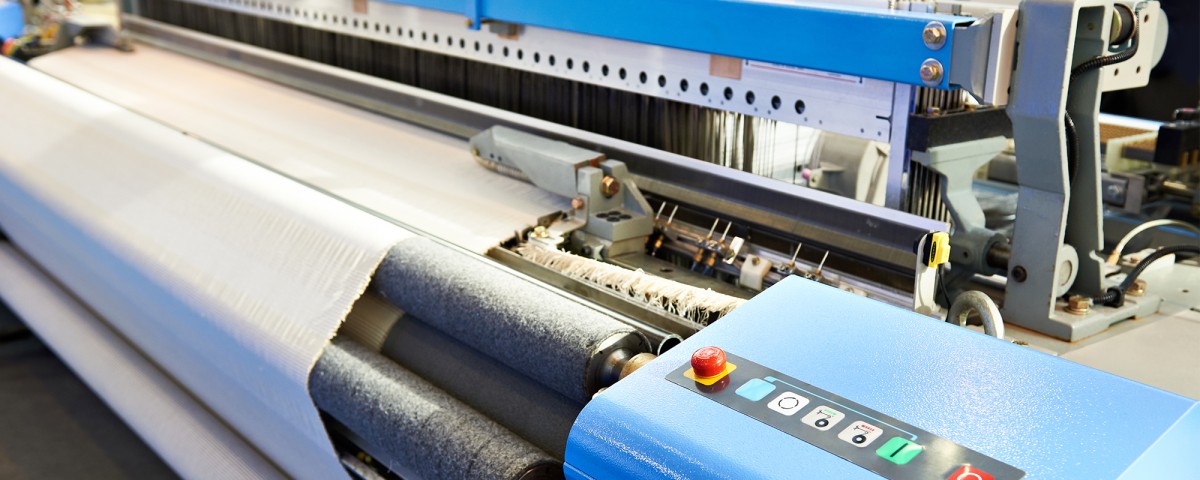 Close-up of an industrial loom producing textiles