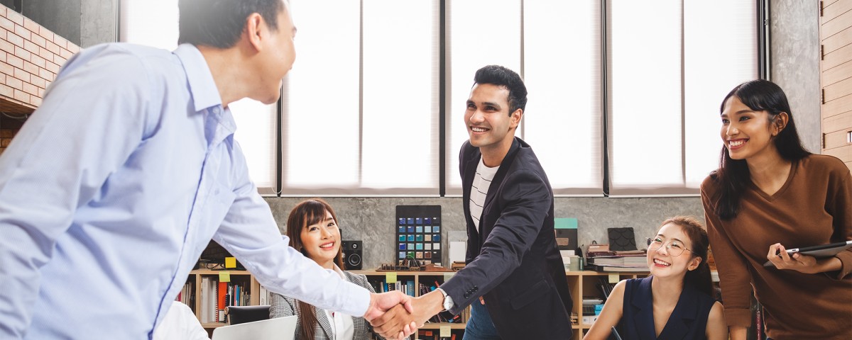 Office workers in Asia shake hands