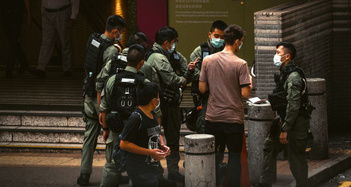 Police personnel question a man on the street