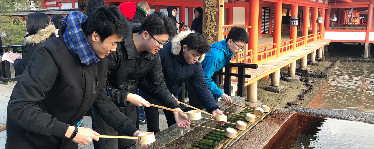 Japanese students standing by a pond