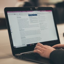 Close-up of someone typing at a laptop