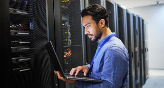 cybersecurity expert at keyboard with graphics