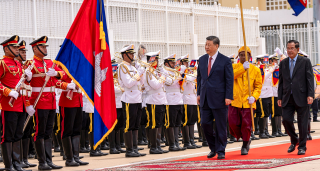 China's President Xi Jinping (C-R) walks with Cambodia's Senate President Hun Sen (R)