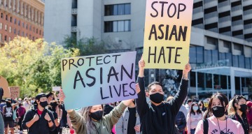 Protesters hold signs against anti-Asian racism