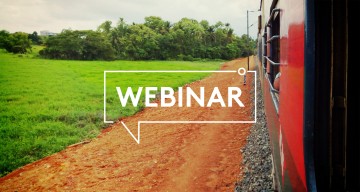 Train travelling across field in India with Webinar text