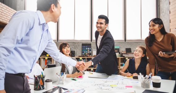 Office workers in Asia greet one another