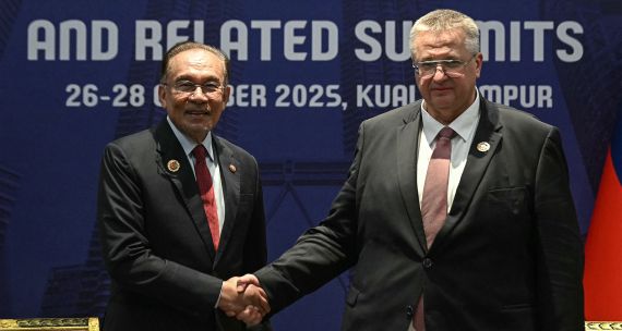 Malaysia's Prime Minister Anwar Ibrahim (L) shakes hands with Russia's Deputy Prime Minister Alexey Overchuk