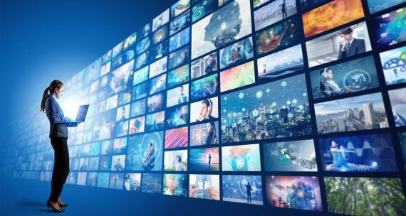 Woman in front of a wall of media screens 