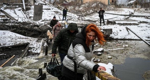 Civilians scramble across a bomb-blasted bridge on the Ukranian capital of Kyiv's northern front March 1, 2022