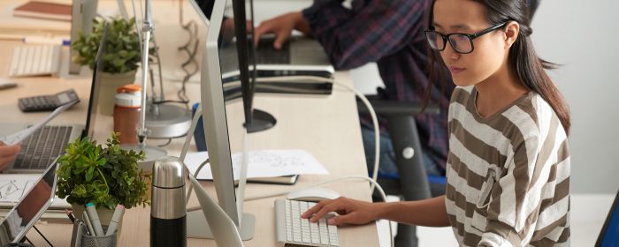 Close-up of Vietnamese woman sitting at her office computer