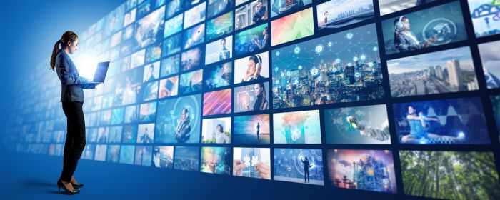 Woman in front of a wall of media screens 