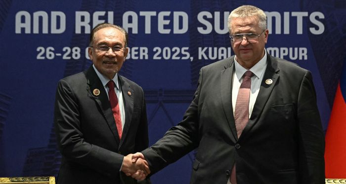 Malaysia's Prime Minister Anwar Ibrahim (L) shakes hands with Russia's Deputy Prime Minister Alexey Overchuk